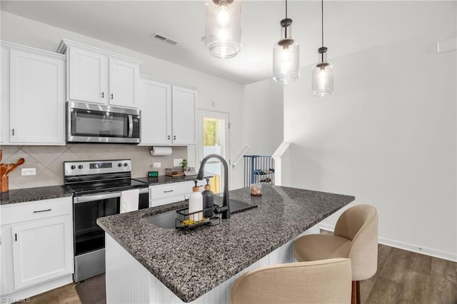 4062 Monteray Cir, High Point, NC 27265 - kitchen with stainless steel appliances, white cabinetry, dark wood-style flooring, and a kitchen breakfast bar