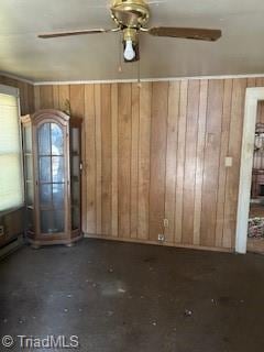 empty room with wooden walls and ceiling fan