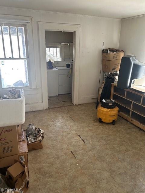 interior space with crown molding, washer and dryer, and a healthy amount of sunlight