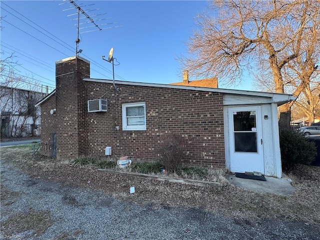 view of side of property with a wall mounted air conditioner