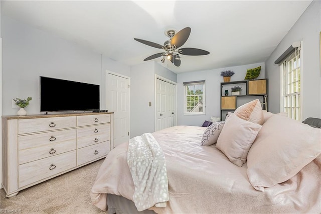 bedroom with a ceiling fan, a closet, and light colored carpet