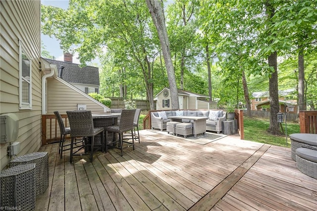 wooden deck featuring an outdoor living space, an outbuilding, outdoor dry bar, a fenced backyard, and a storage unit