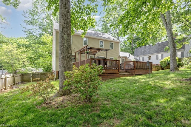 rear view of house with a fenced backyard, a lawn, and a deck
