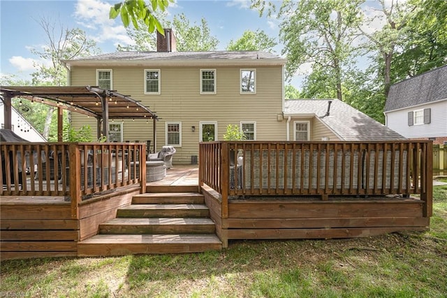 rear view of house featuring a pergola, a chimney, and a deck