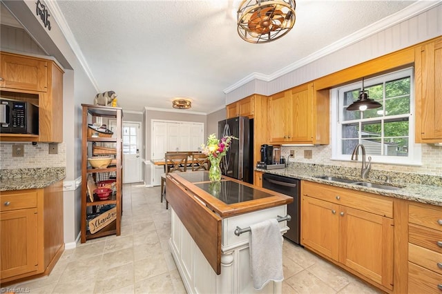kitchen featuring crown molding, a sink, black appliances, and tasteful backsplash