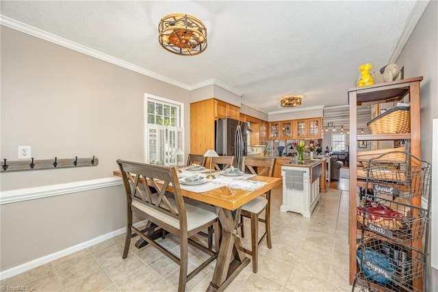 dining area with crown molding, light tile patterned floors, a textured ceiling, and baseboards