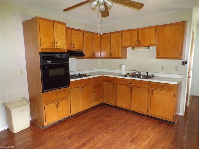 2600 Alamance Church Rd, Greensboro, NC 27406 - kitchen with black oven, under cabinet range hood, ceiling fan, cooktop, and wood finished floors