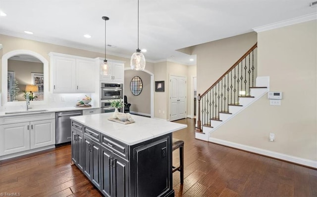 kitchen featuring sink, a center island, dark wood-type flooring, white cabinets, and appliances with stainless steel finishes