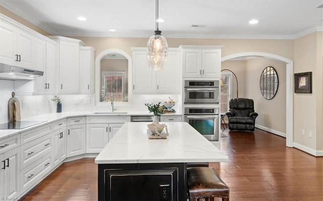 kitchen featuring a center island, sink, black electric cooktop, white cabinetry, and stainless steel double oven