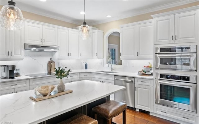 kitchen with sink, white cabinets, hanging light fixtures, and appliances with stainless steel finishes