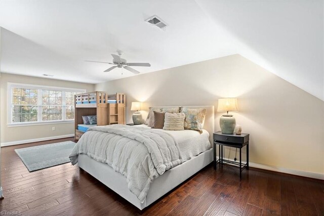 bedroom with dark hardwood / wood-style flooring, vaulted ceiling, and ceiling fan