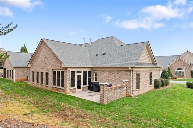 back of property with a yard and a patio area