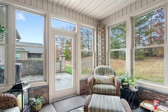 sunroom / solarium with a healthy amount of sunlight and wood ceiling