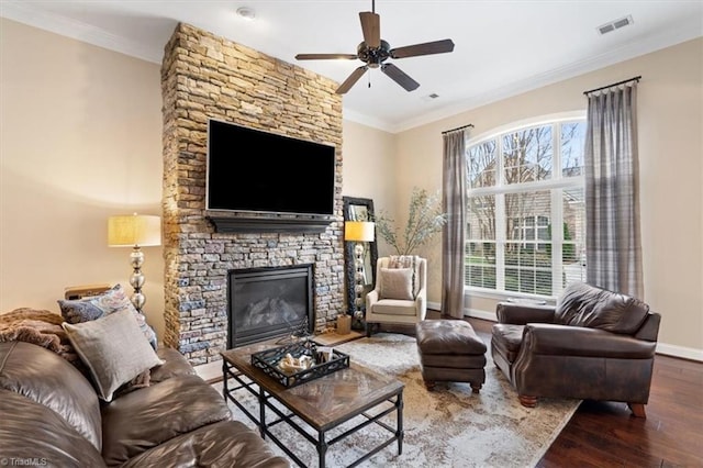 living room featuring dark hardwood / wood-style floors, a fireplace, crown molding, and ceiling fan