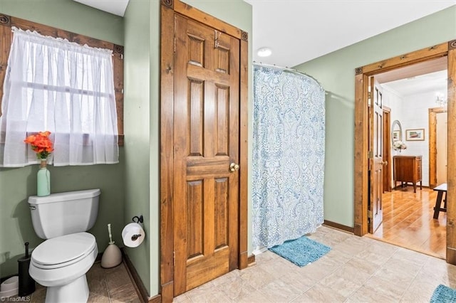 bathroom with toilet and a shower with shower curtain