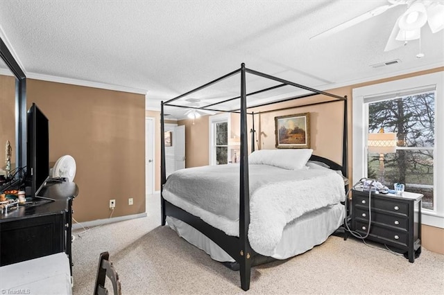 carpeted bedroom featuring crown molding, ceiling fan, and a textured ceiling