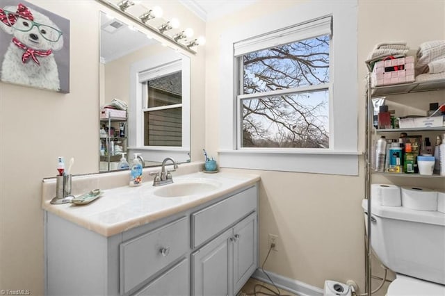 bathroom featuring vanity, crown molding, and toilet