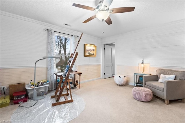 sitting room featuring light carpet, crown molding, and a textured ceiling