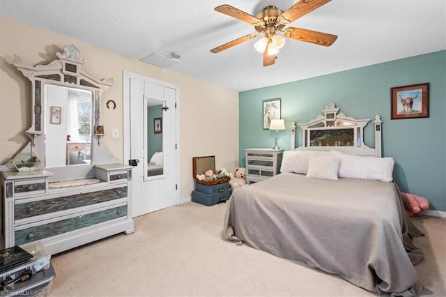 carpeted bedroom with ceiling fan and a textured ceiling