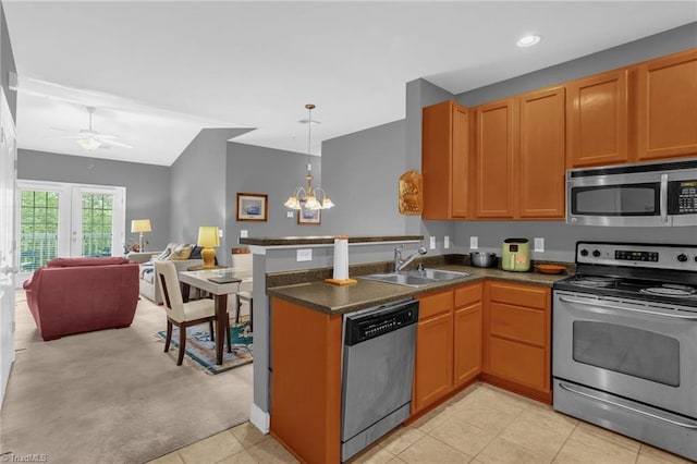 4455 Brassfield Dr Unit 306, Winston-Salem, NC 27105 - kitchen featuring stainless steel appliances, a sink, a peninsula, dark countertops, and a chandelier