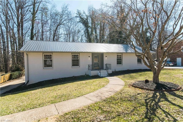 single story home with a front yard and metal roof