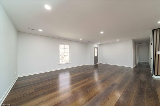 spare room with recessed lighting, visible vents, and dark wood-type flooring