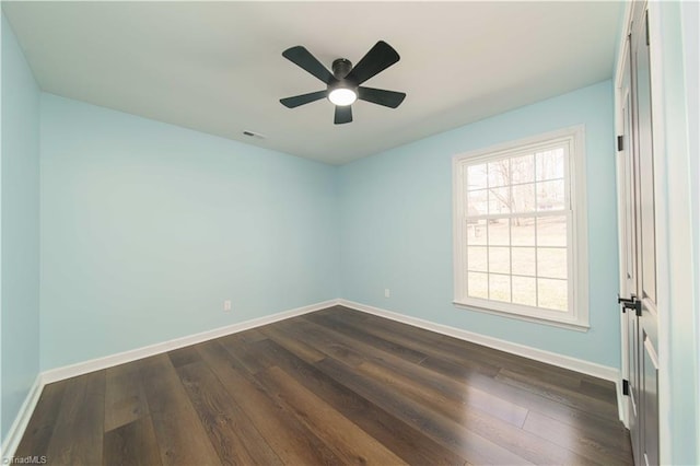 unfurnished room featuring baseboards, dark wood-type flooring, and a ceiling fan