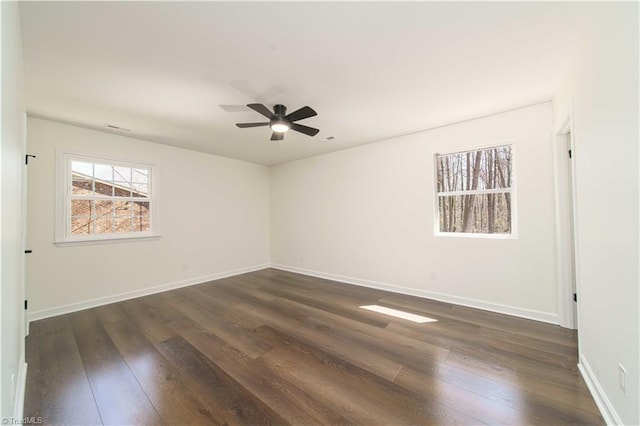 spare room featuring baseboards, dark wood-style flooring, and ceiling fan