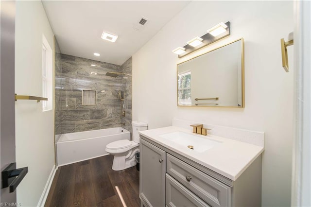 bathroom with washtub / shower combination, toilet, vanity, and wood finished floors