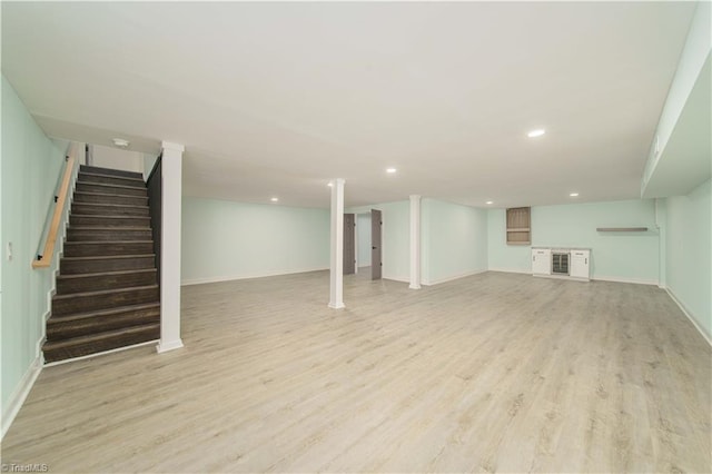 finished basement with recessed lighting, stairway, baseboards, and light wood-style flooring