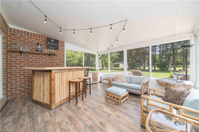 sunroom / solarium with rail lighting, an outdoor hangout area, a healthy amount of sunlight, and outdoor dry bar