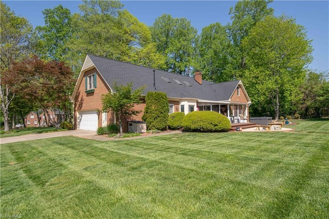 view of front of property featuring a front lawn, concrete driveway, a garage, brick siding, and a sunroom