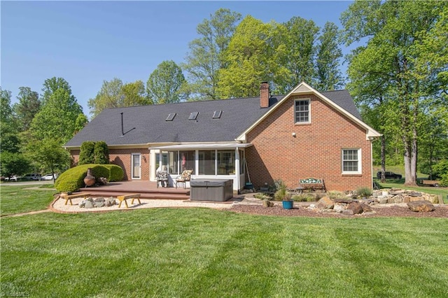 rear view of house with a patio area, a lawn, and a hot tub