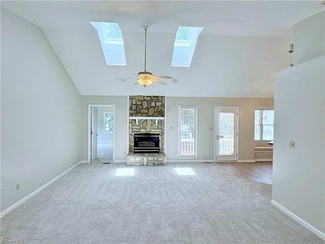 204 Maplewood Ct, Trinity, NC 27370 - unfurnished living room featuring a skylight, carpet, a stone fireplace, ceiling fan, and high vaulted ceiling