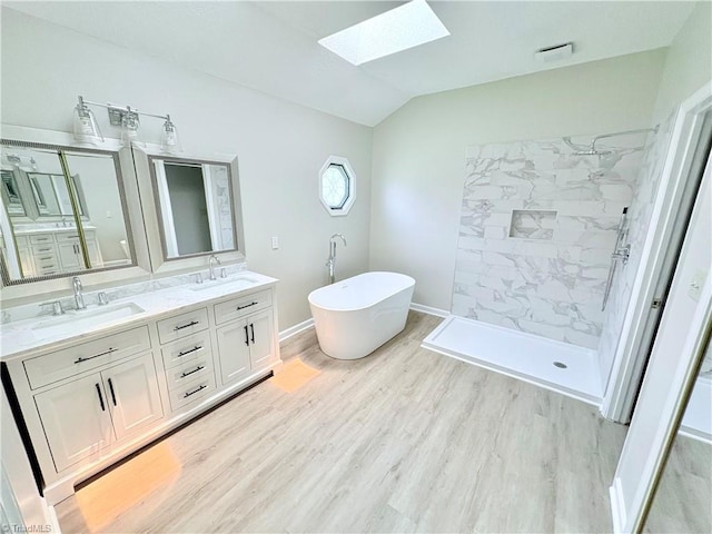 204 Maplewood Ct, Trinity, NC 27370 - bathroom featuring a skylight, lofted ceiling, a freestanding bath, a marble finish shower, and double vanity