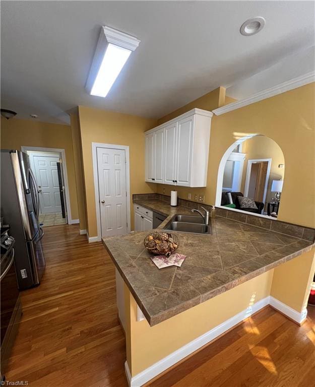 kitchen with sink, a kitchen breakfast bar, white cabinets, and kitchen peninsula