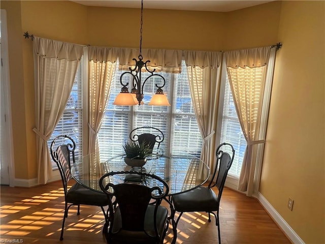 dining area with plenty of natural light, a chandelier, and hardwood / wood-style floors