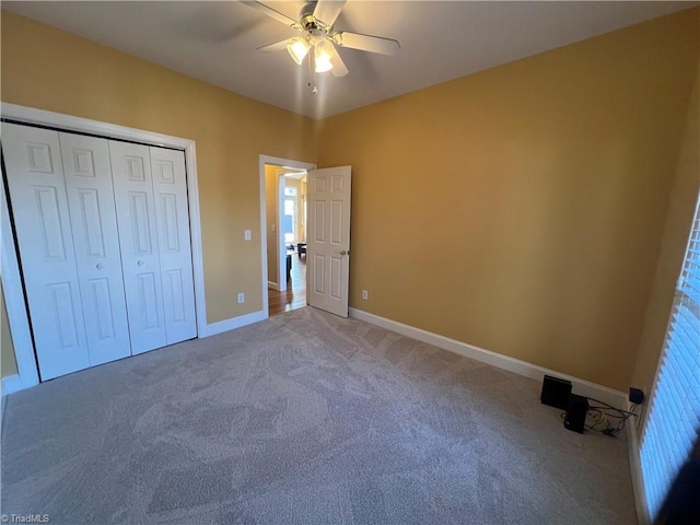 unfurnished bedroom with ceiling fan, carpet, and a closet