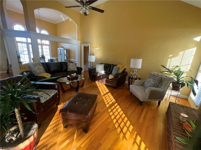 living room featuring ceiling fan, a high ceiling, and hardwood / wood-style flooring