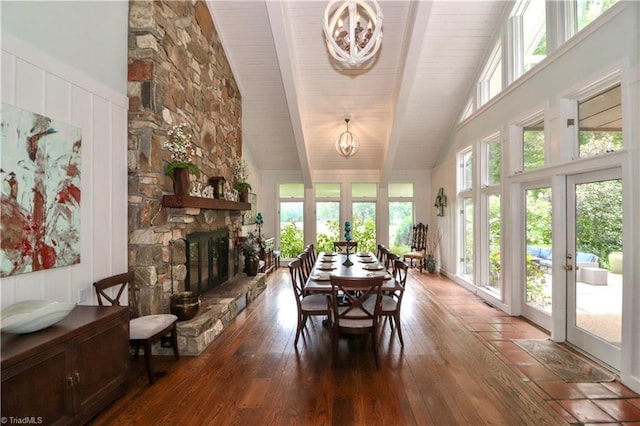 dining room featuring high vaulted ceiling, wood finished floors, a healthy amount of sunlight, and an inviting chandelier