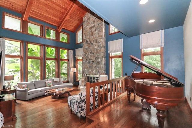 sitting room with wood ceiling, wood finished floors, beamed ceiling, a fireplace, and high vaulted ceiling