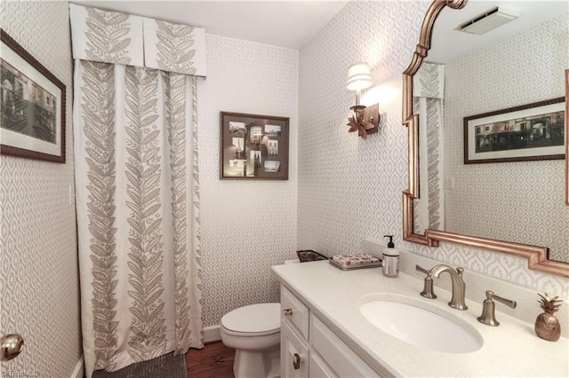 bathroom featuring hardwood / wood-style floors, toilet, vanity, and curtained shower