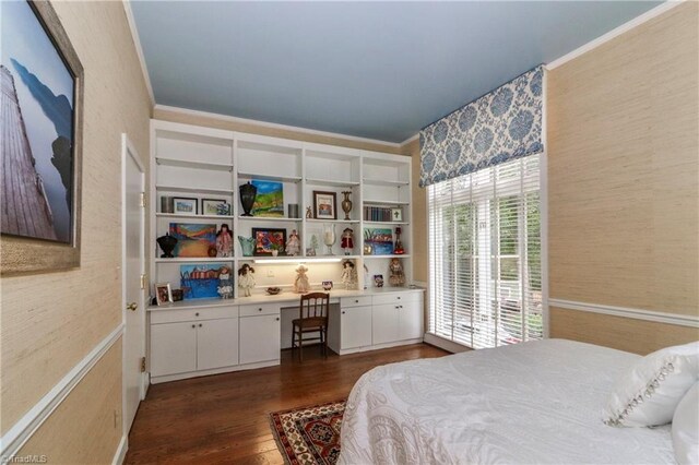 bedroom featuring ornamental molding, dark wood-style flooring, and built in study area