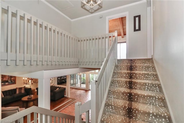 staircase featuring an inviting chandelier and ornamental molding