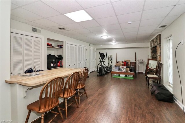 interior space featuring sink, built in shelves, hardwood / wood-style floors, and a drop ceiling