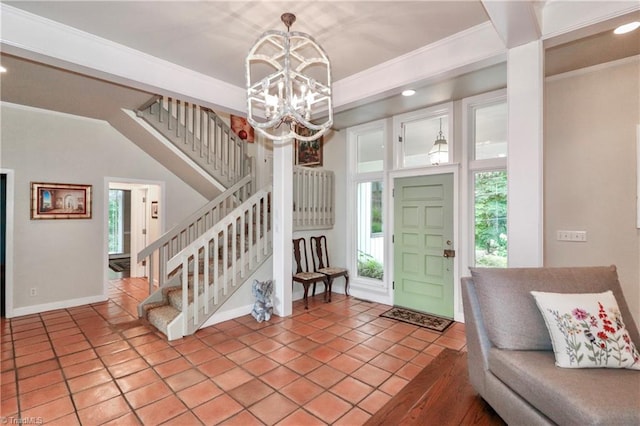 tiled entrance foyer with a notable chandelier and ornamental molding