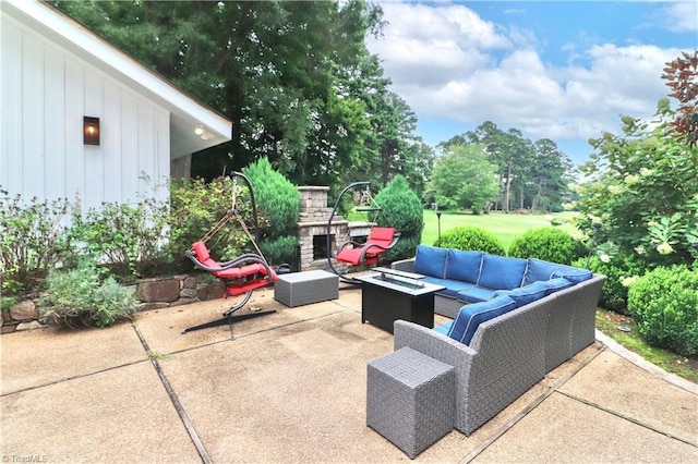 view of patio with an outdoor living space with a fireplace