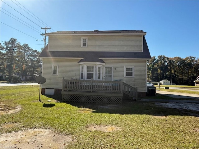 rear view of house featuring a deck and a yard