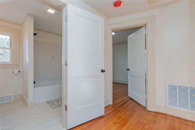 full bathroom featuring  shower combination, crown molding, visible vents, and wood finished floors