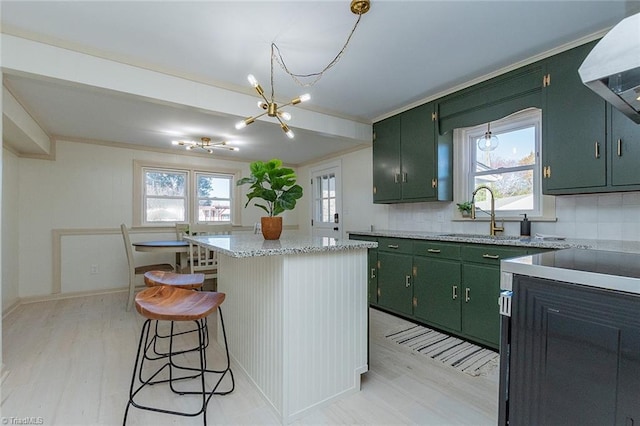 kitchen featuring a sink, green cabinets, backsplash, a center island, and wall chimney exhaust hood